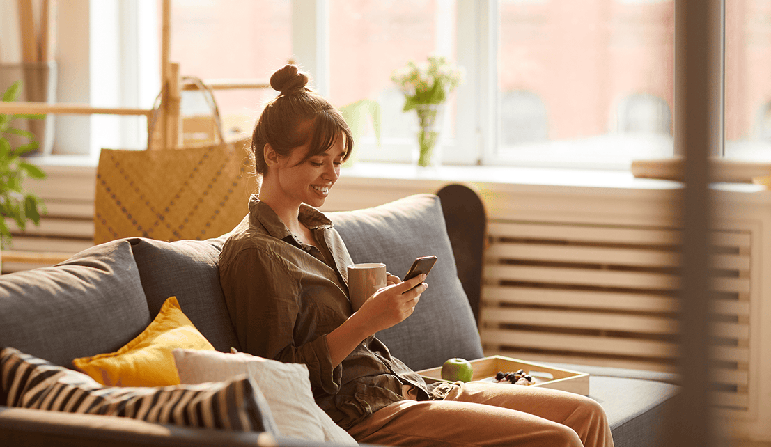 Woman using her smartphone in a relaxed home environment.