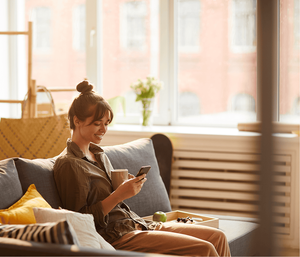 Woman using her smartphone in a relaxed home environment.